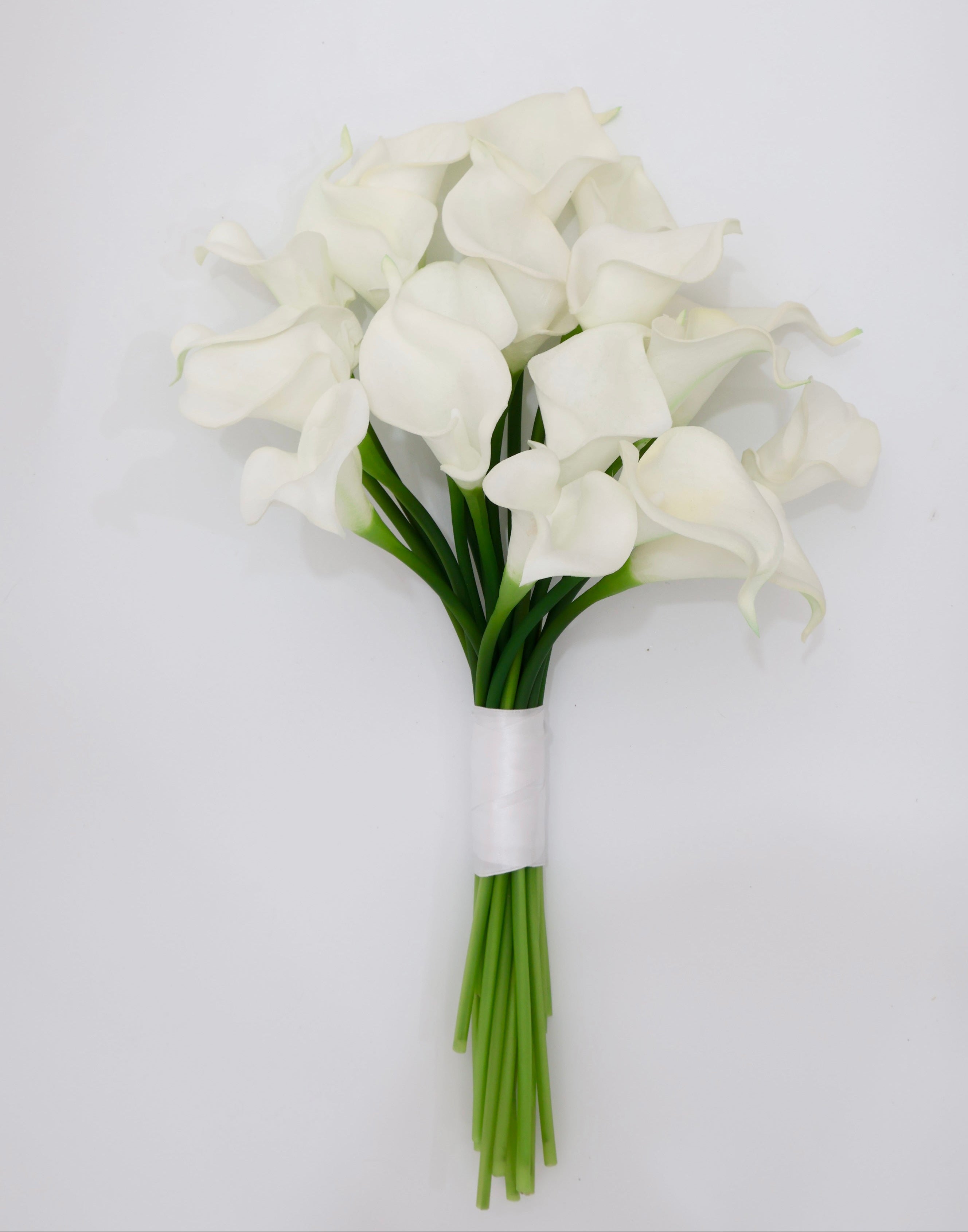 Bouquet of white flowers with green stems on a light gray background