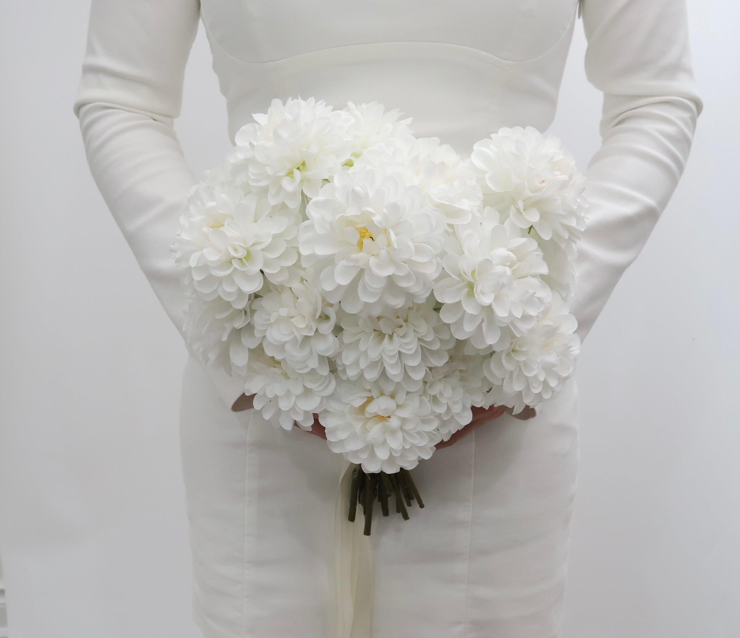 Bouquet of white dahlia flowers with a ribbon on a white background