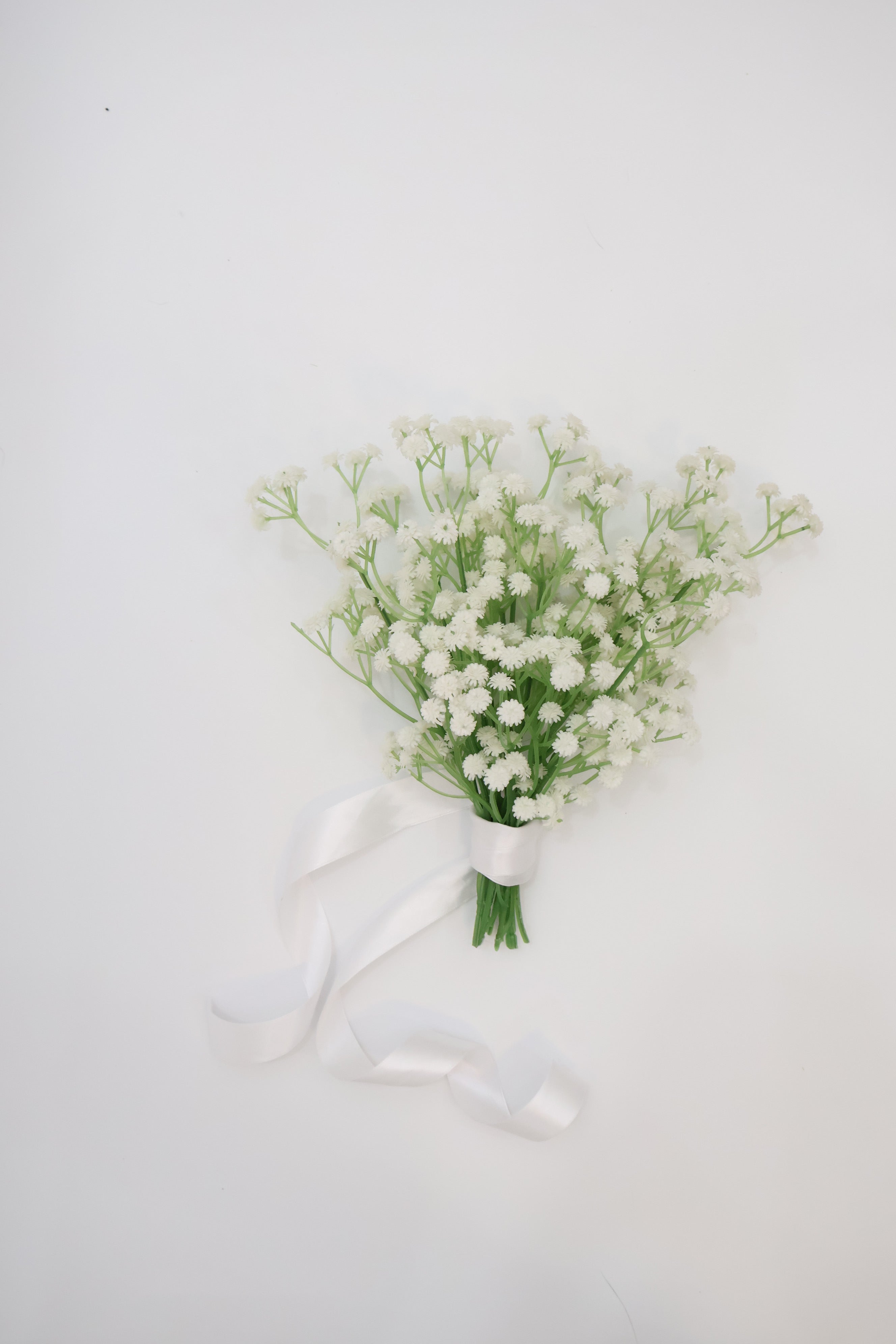 Bridal holding a bouquet of white baby's breath flowers with a wedding dress