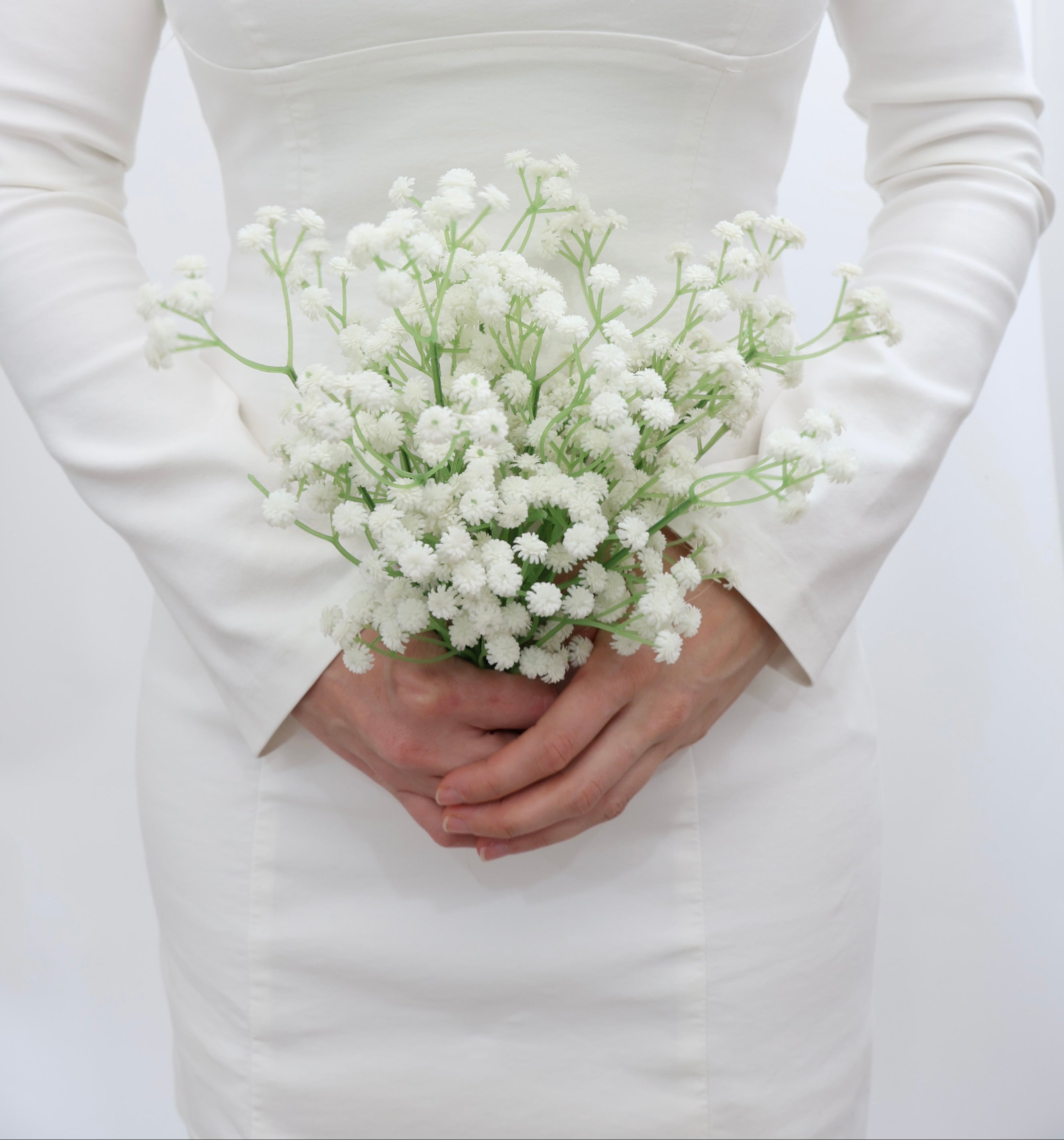 Bridal holding a bouquet of white baby's breath flowers with a wedding dress